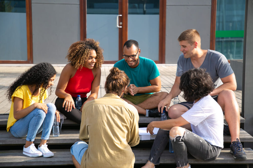 Gestão urbana: um grupo de pessoas sentados na escada conversando sobre a participação social.